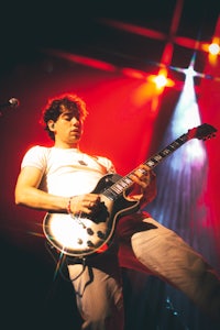 a man playing a guitar on stage