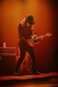 a man in a hat playing a guitar