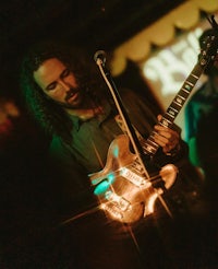 a man playing a guitar in a dark room